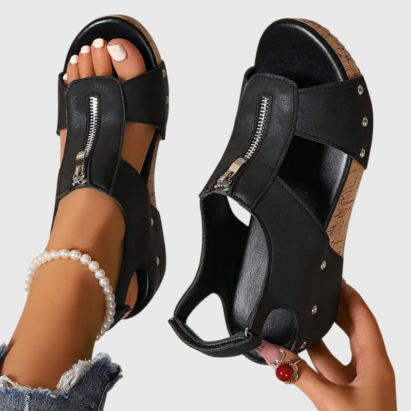 Black orthopedic sandals with center zipper detail and cutout straps — front and side angle view