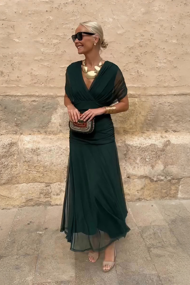 Women's dark green V-neck maxi dress with sheer mesh sleeves and flowing skirt — full body front view