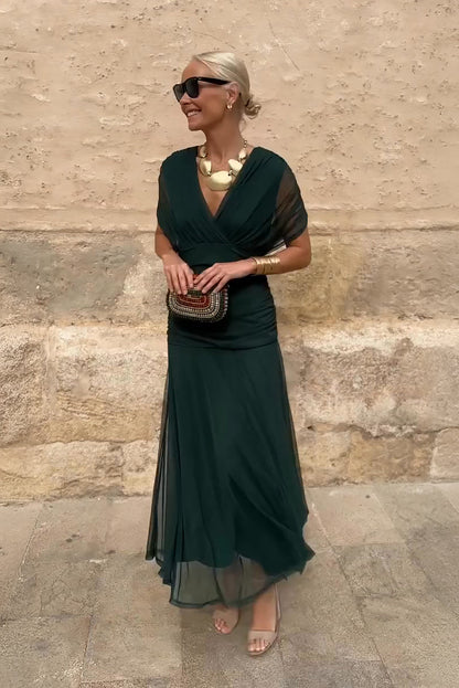 Women's dark green V-neck maxi dress with sheer mesh sleeves and flowing skirt — full body front view