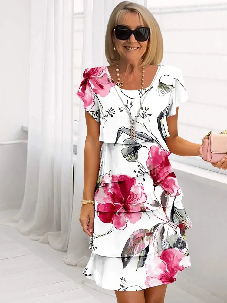 Women's white midi dress with pink floral print and ruffled hem — front view on model