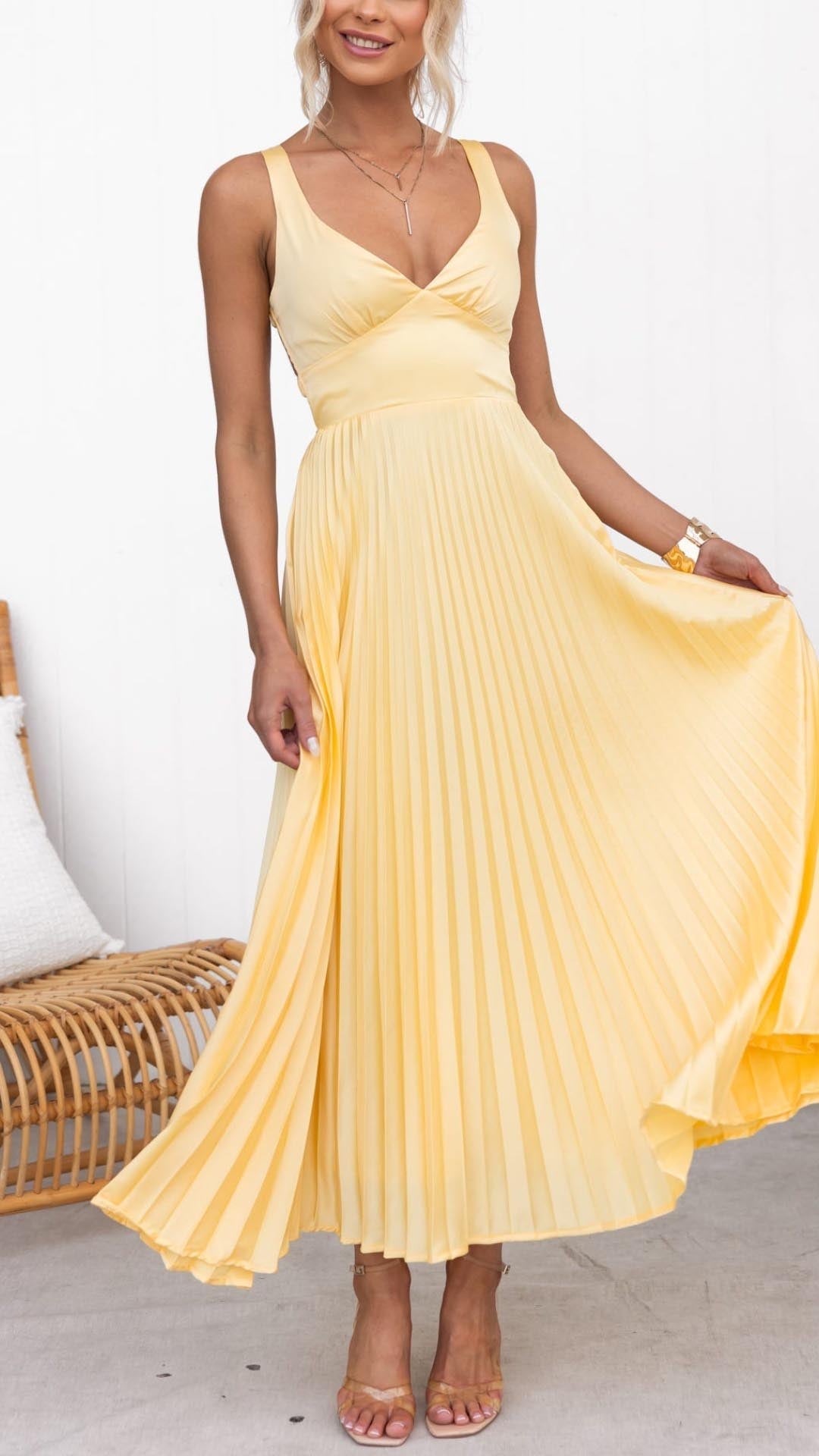 Pale yellow pleated maxi dress with V-neck and flowing skirt — front view