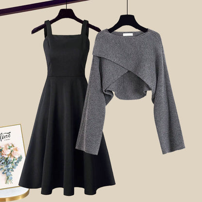 Black A-line midi dress with spairing straps and gray wrap sweater on hangers — front view