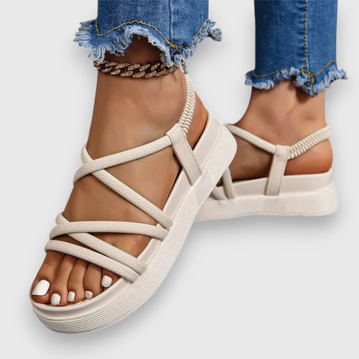 Beige strappy platform sandals with textured soles and elastic bands — angled front view on model wearing distressed jeans