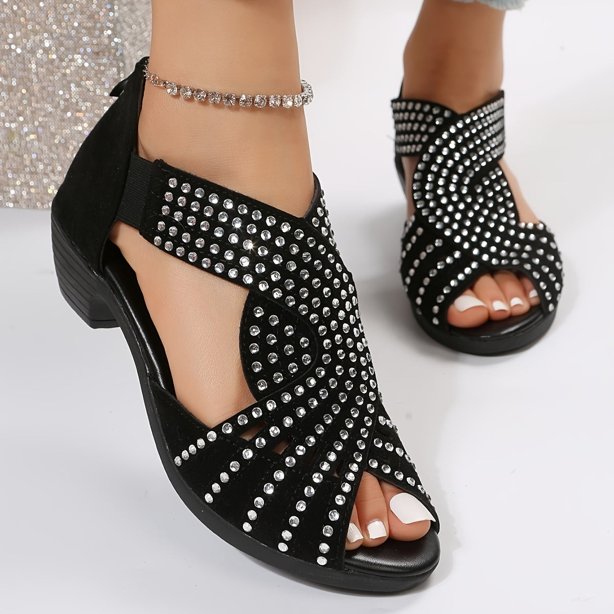 Black studded flat sandals with rhinestone embellishments and ankle ties — front angled view