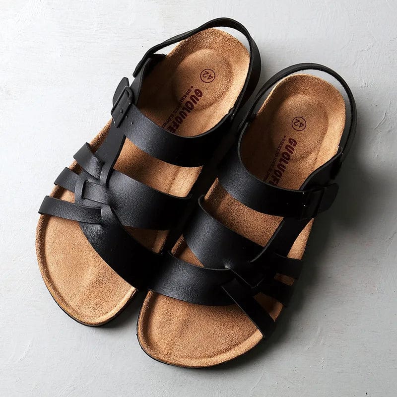 Black strappy gladiator sandals with cork footbed and adjustable buckles — overhead view