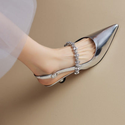 Silver pointed-toe slingback pumps with crystal embellished strap — side view on foot