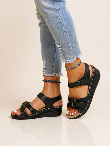 Women's black wedge sandals with adjustable buckle straps and white contrast stitching — side view