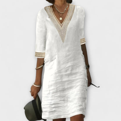 White linen shift dress with crochet lace V-neck and sleeve trim — front view