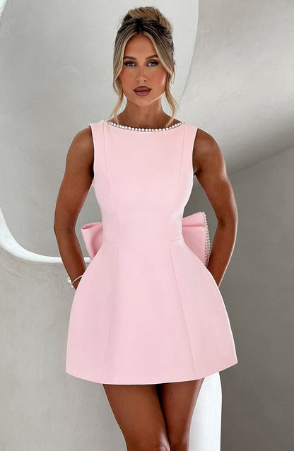 Pink A-line mini dress with pearl neckline detail and pockets — front view on model