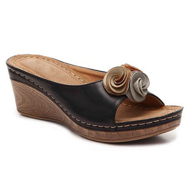 Black leather wedge sandal with decorative rosette detail — side view
