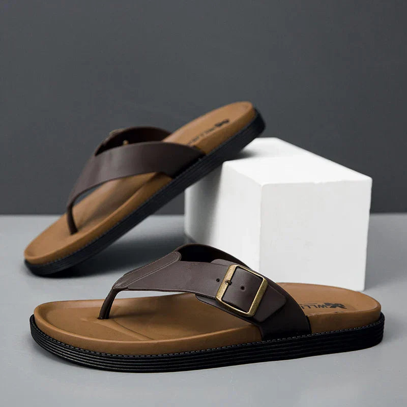 Brown vegan leather flip-flop sandals with buckle detail and tan footbed — angled side view