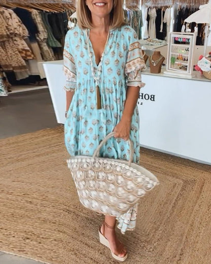 Turquoise boho midi dress with floral print and tassel trim details — full front view