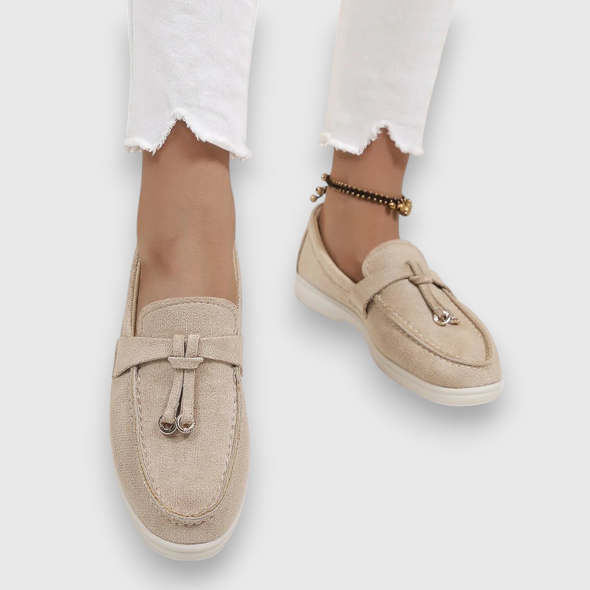 Beige suede slip-on loafers with metal toggle detail and white platform sole — overhead view