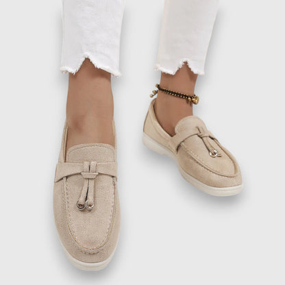 Beige suede slip-on loafers with metal toggle detail and white platform sole — overhead view