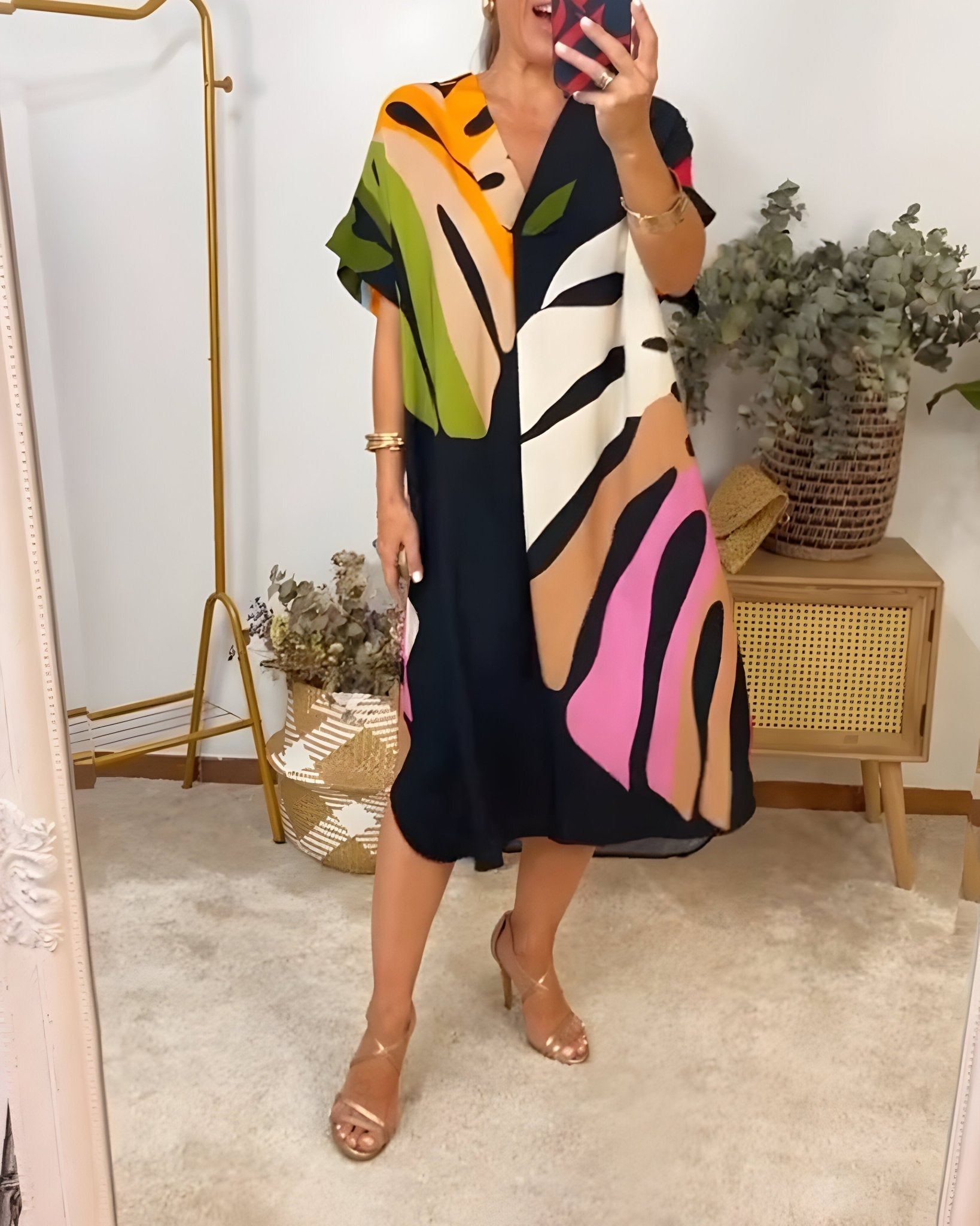 Women's black maxi dress with bold colorful abstract print in orange, green, pink, and beige — front view