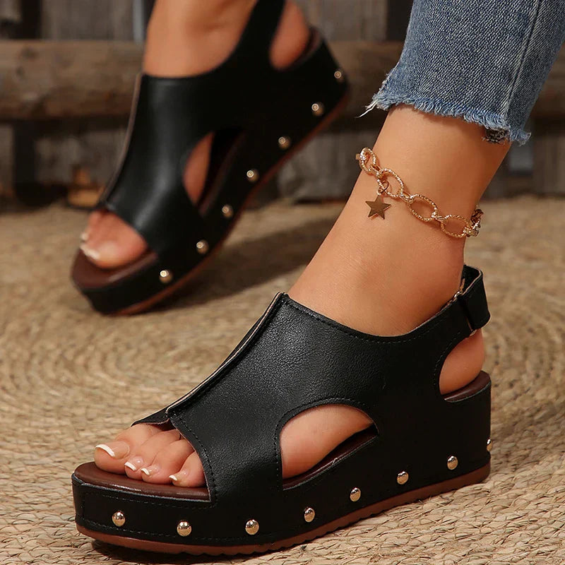 Women's black platform sandals with cutout design and studded sole — front angled view
