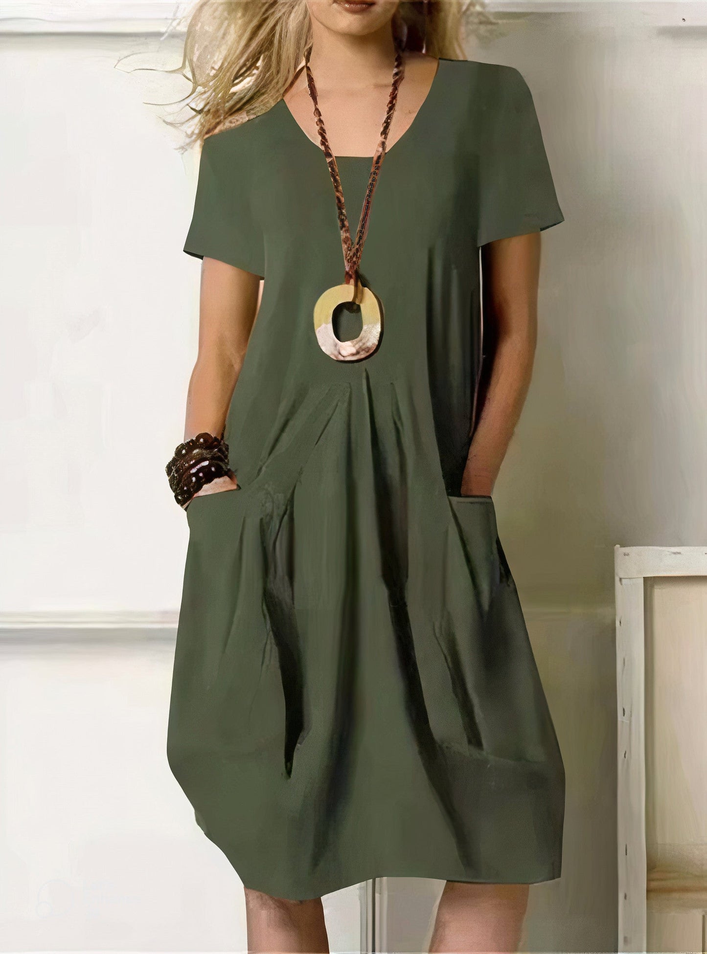 Olive green short-sleeve midi dress with side pockets and pleated detail — front view