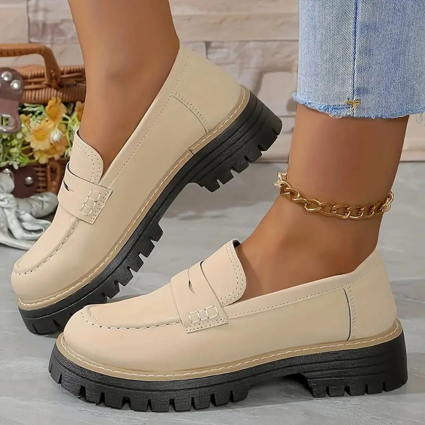 Beige chunky platform loafers with lug soles and gold ankle chain — side view on model