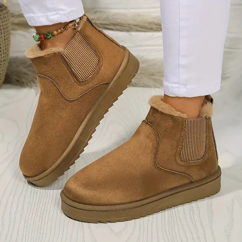 Women's tan suede ankle boots with fur lining and elastic side panels — three-quarter front view