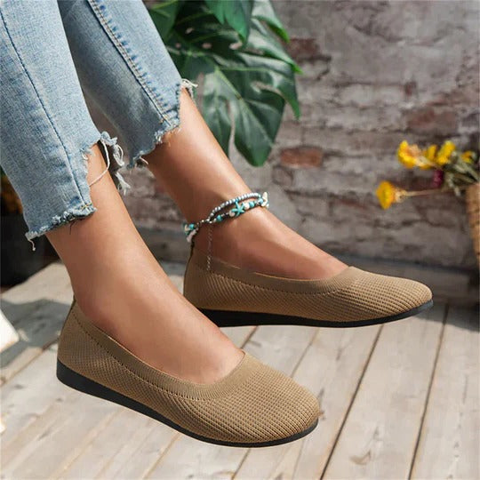 Women's tan knit slip-on ballet flats with beaded ankle bracelet — angled front view