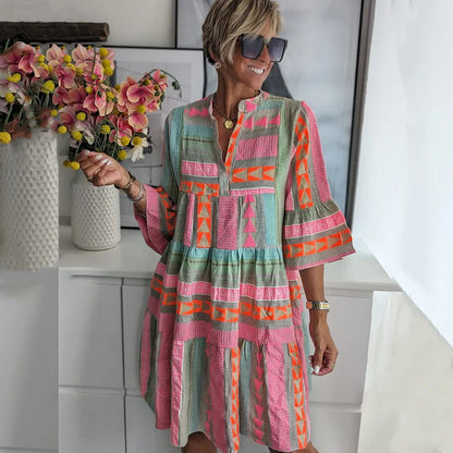 Colorful geometric patterned tiered midi dress with bell sleeves — front view on model
