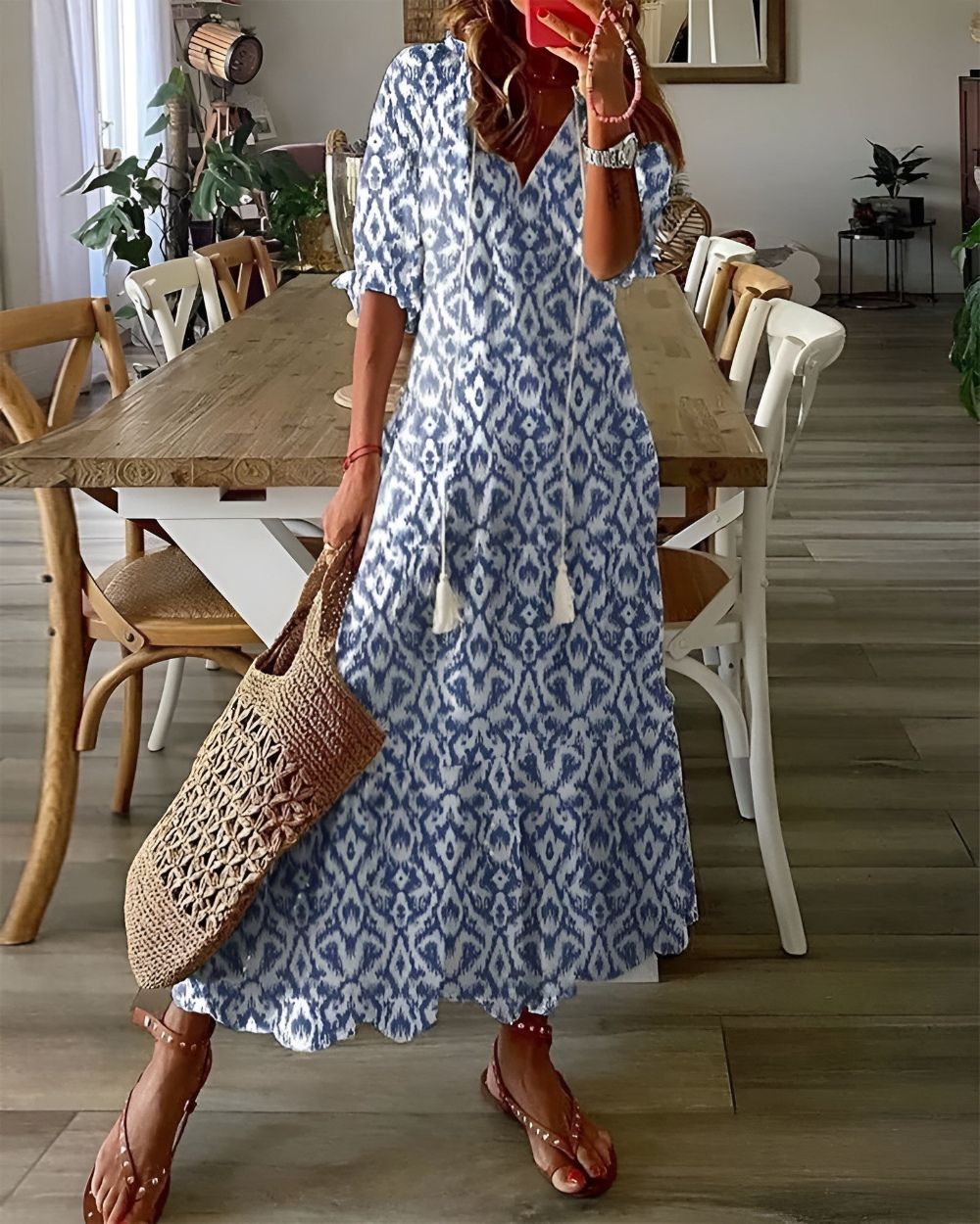 Blue and white ikat print maxi dress with tassel ties — front view on model in dining room