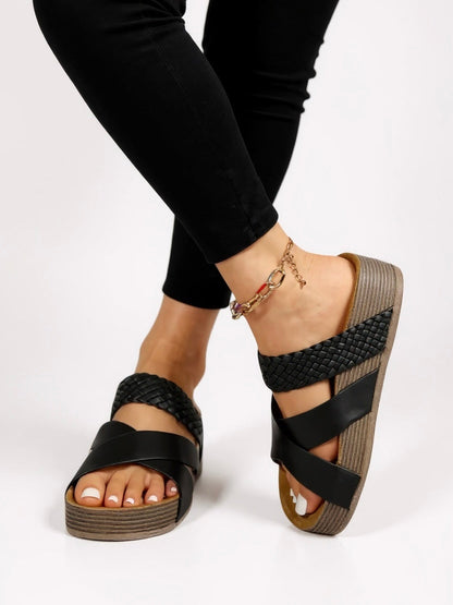 Black woven strap platform sandals with cushioned sole — side angle on model wearing black jeans