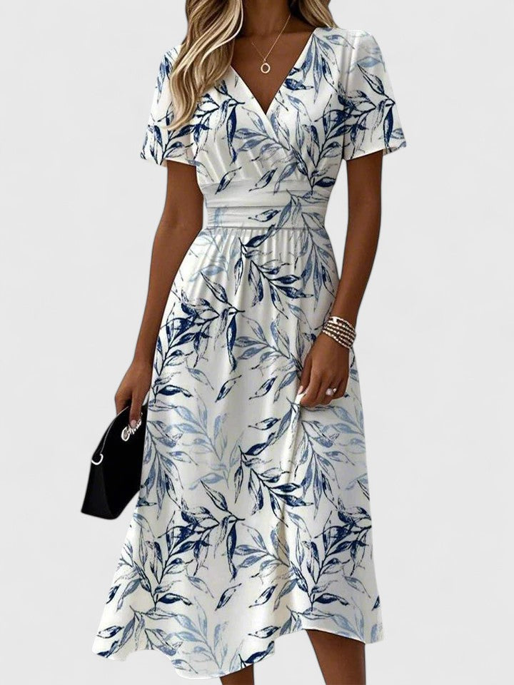 Women's white midi dress with blue leaf print and wrap waist detail — front view