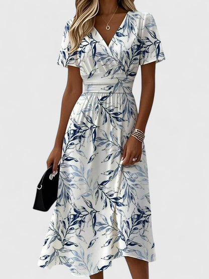 Women's white midi dress with blue leaf print and wrap waist detail — front view