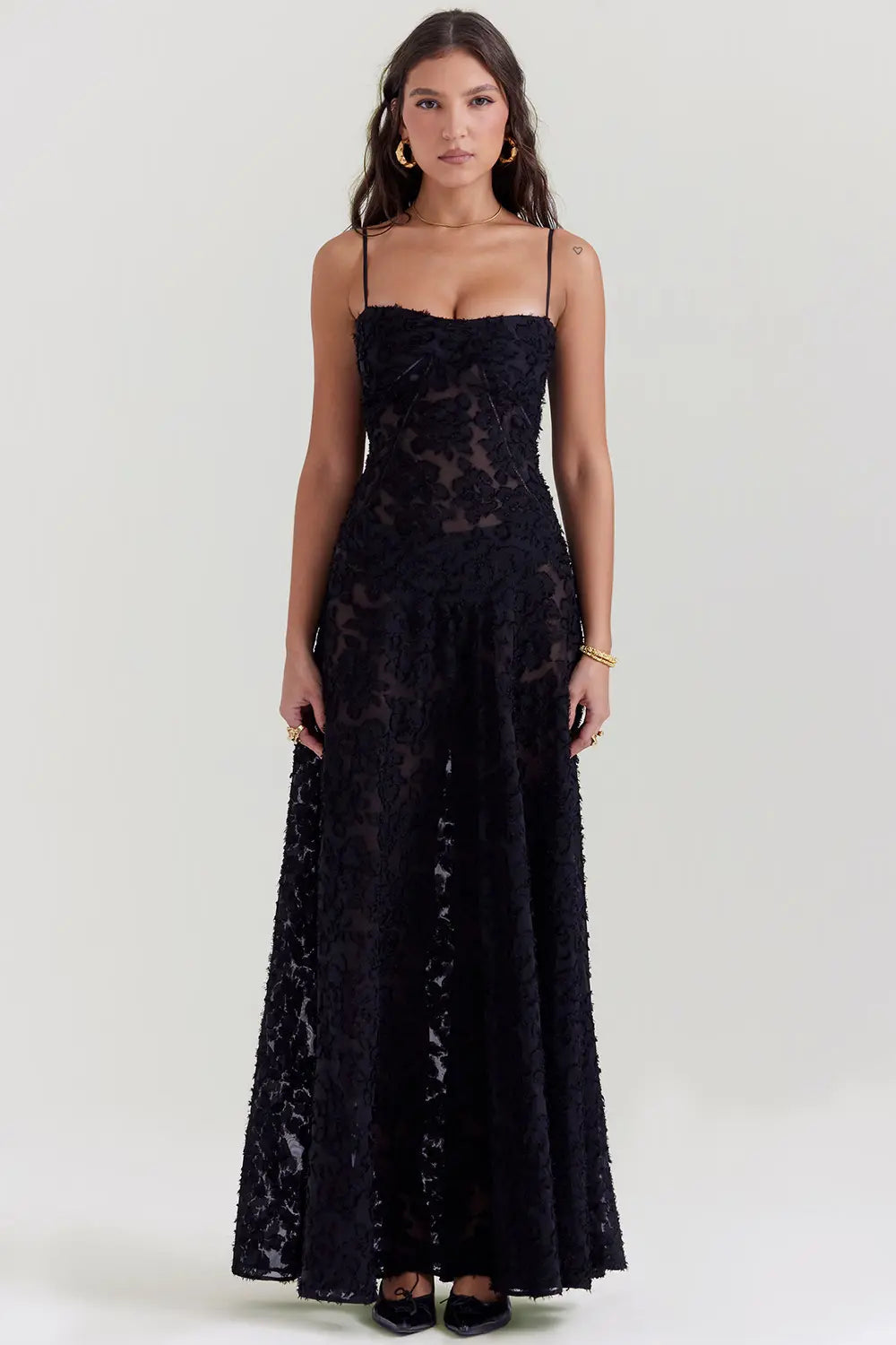 Black textured maxi dress with spaghetti straps and floral appliqué details — front view
