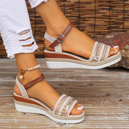 Women's boho woven platform sandals with brown ankle strap and embellished toe band — side view on model