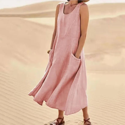 Pink sleeveless midi dress with pockets on model in desert — front angled view