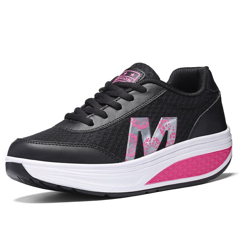 Black orthopedic walking sneaker with pink accents and curved rocker sole — side view