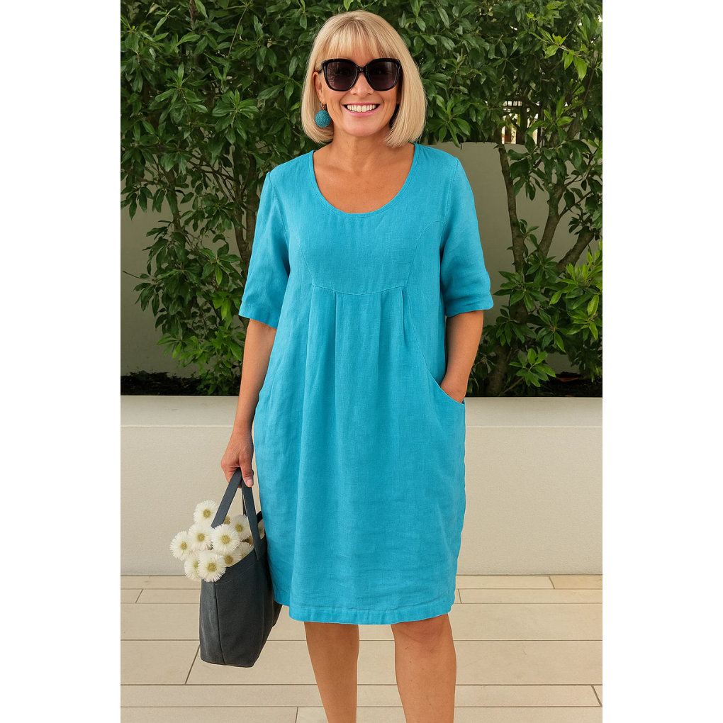Woman wearing turquoise linen midi dress with pockets and half sleeves — front view