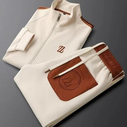 Cream tracksuit with brown leather trim and logo details — flat lay view