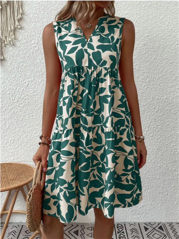 Women's sleeveless midi dress with green leaf print on cream background — front view