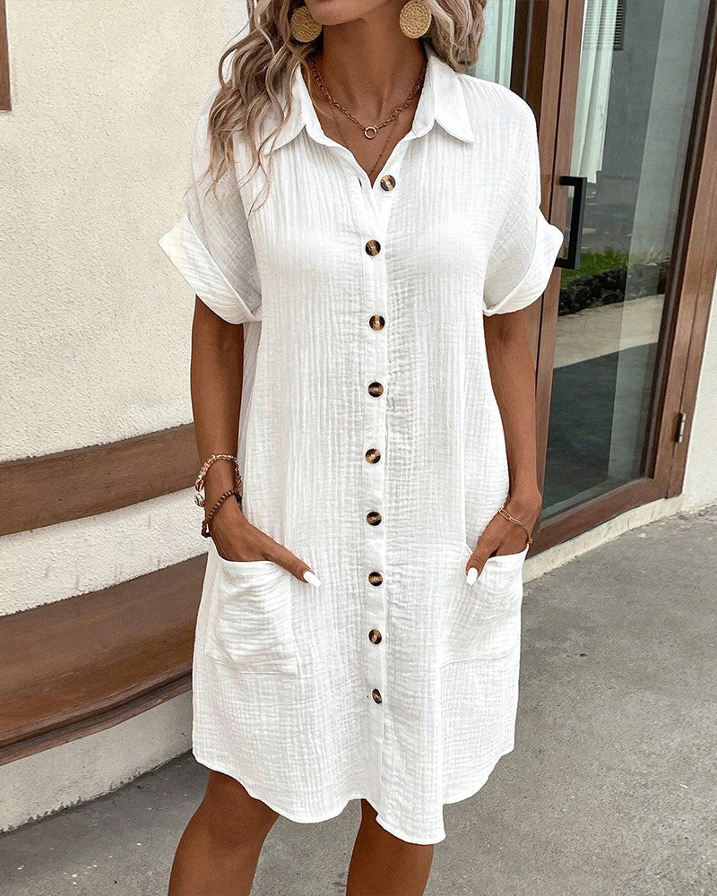 White button-front shirt dress with short sleeves and pockets — front view on model