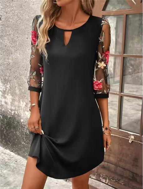 Black v-neck dress with sheer floral embroidered sleeves — front view on model