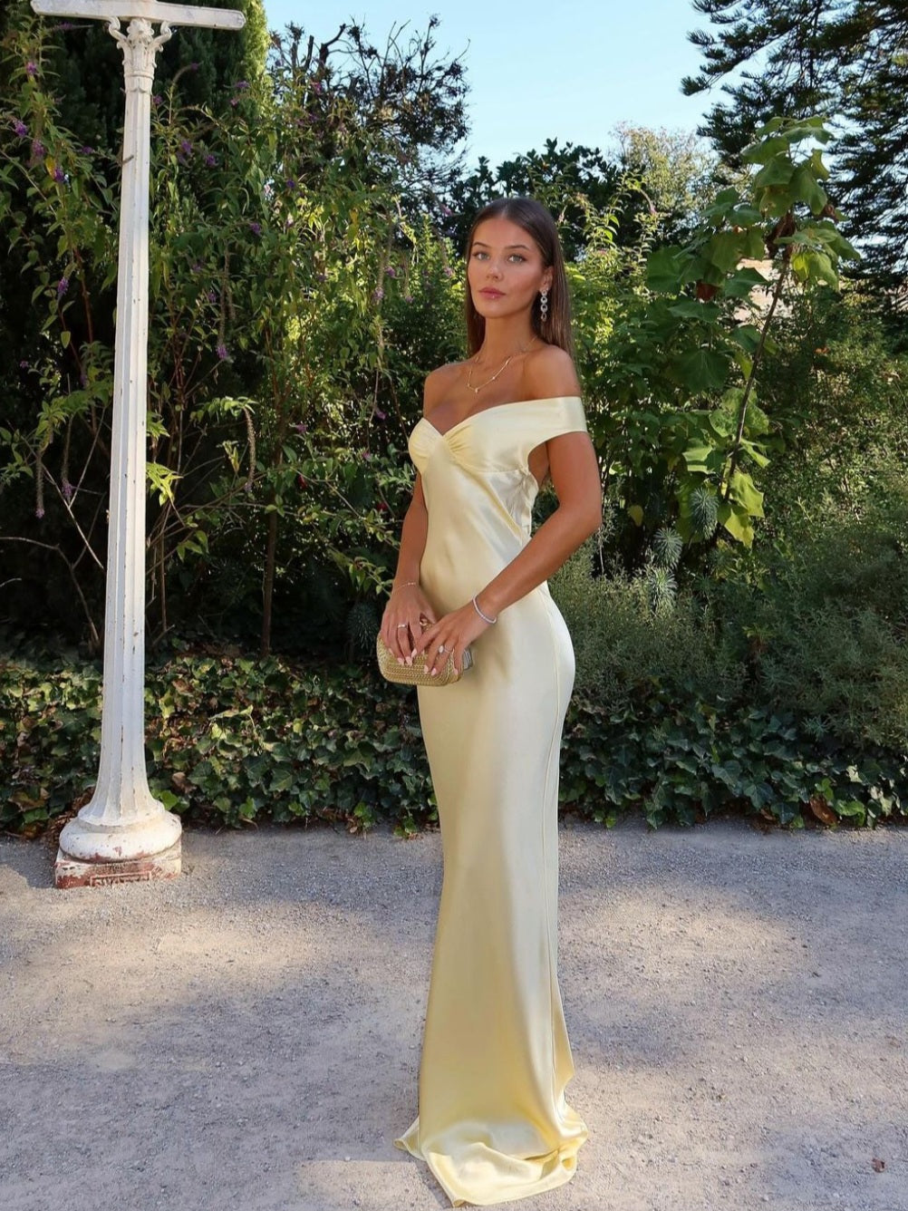 Pale yellow satin off-shoulder evening gown with draped bodice — front view