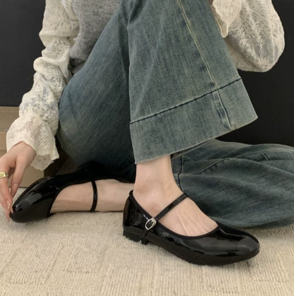 Black patent Mary Jane shoes with ankle strap and low block heel — side view on model