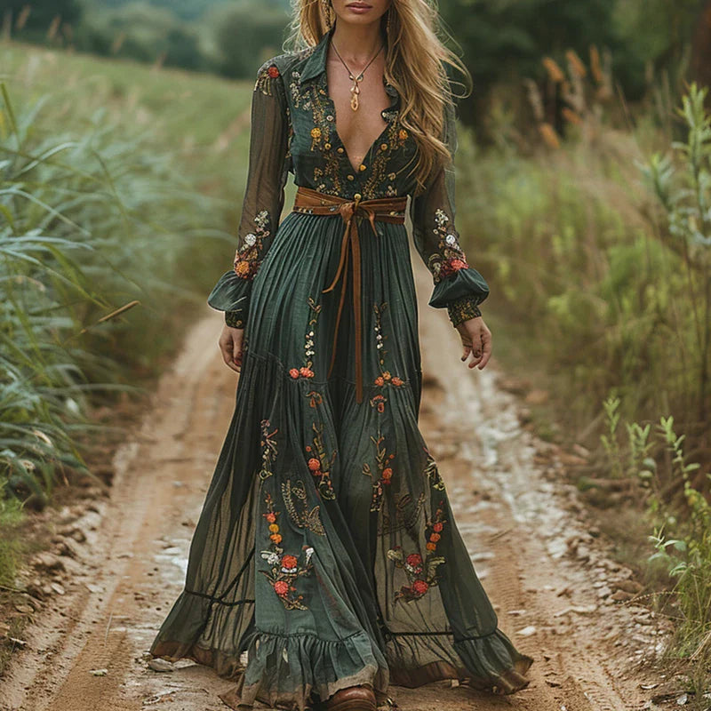 Embroidered floral maxi dress with sheer sleeves and brown belt — front view on outdoor path