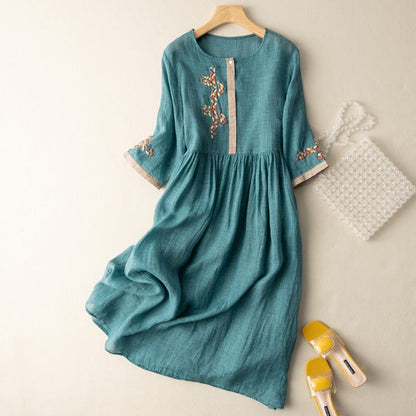 Teal linen midi dress with embroidered neckline and bell sleeves — flat lay view