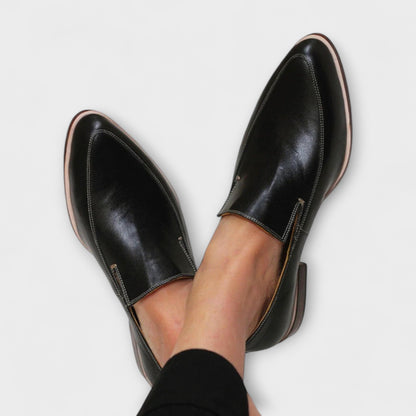 Black leather pointed-toe slip-on loafers with contrast stitching — overhead view on feet