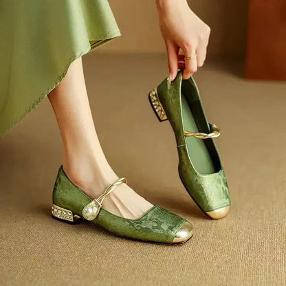 Green velvet Mary Jane block heels with pearl ankle strap and gold cap toe — angled side view