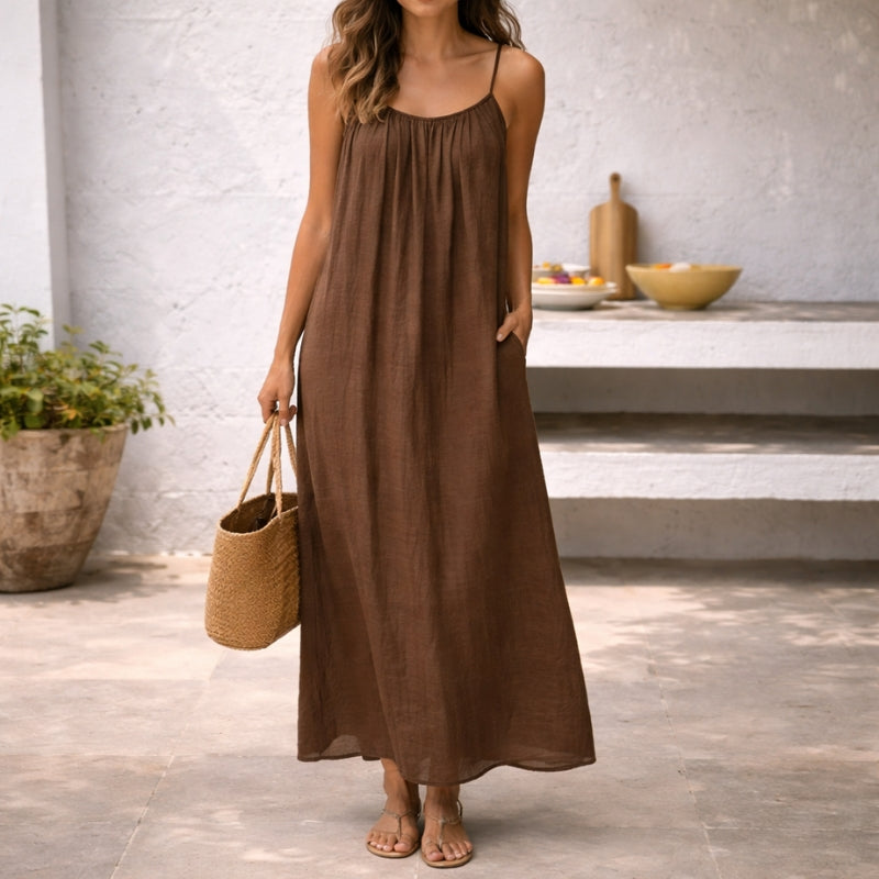 Brown linen maxi dress with spaghetti straps and side pockets — front view on model