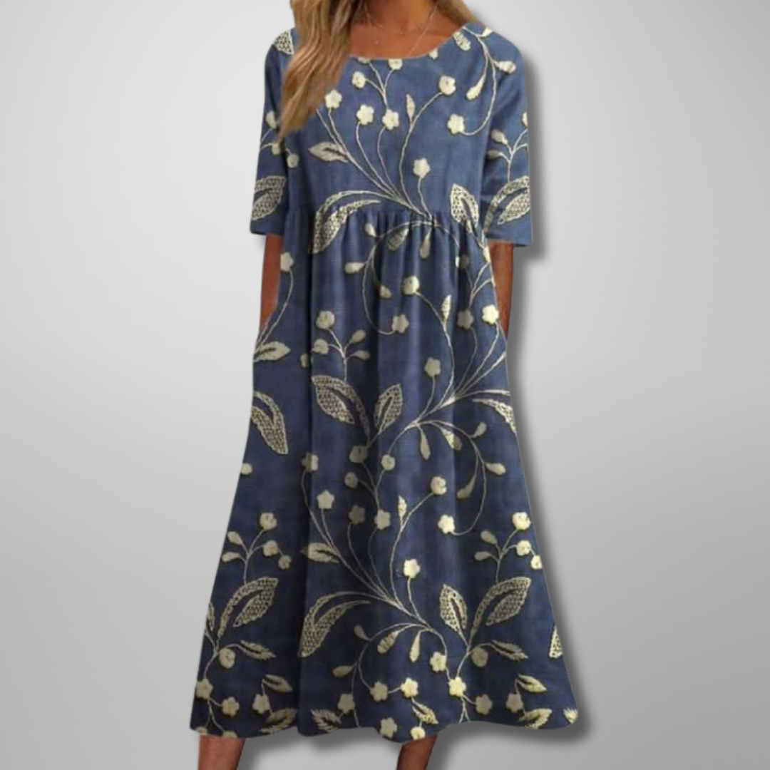 Women's blue midi dress with cream floral vine print and elbow-length sleeves — front view