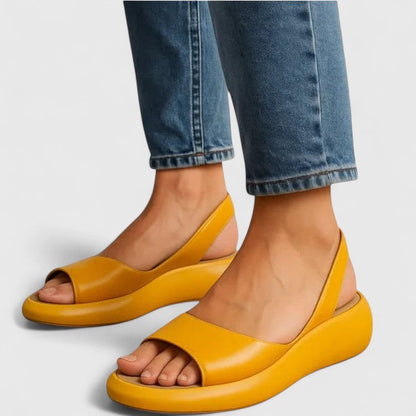 Yellow platform slingback sandals with open toe on model wearing jeans — side angle view