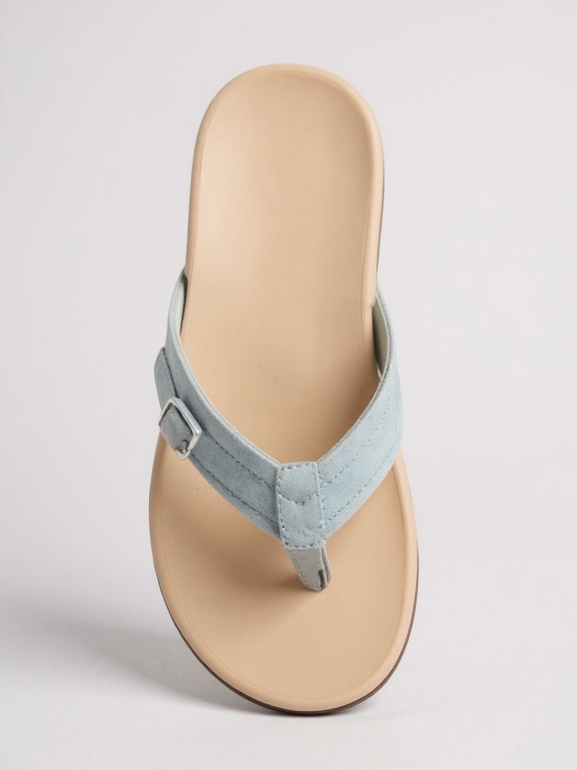 Light blue suede thong sandal with beige footbed and buckle detail — angled front view