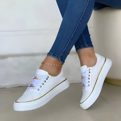 White platform sneakers with gold chain detail and lace-up design — side view on model wearing jeans