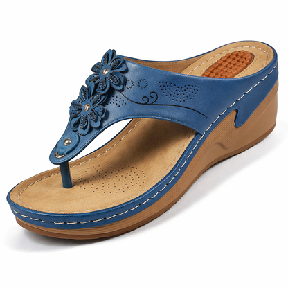Blue wedge thong sandal with flower decoration and perforated leather — three-quarter front view